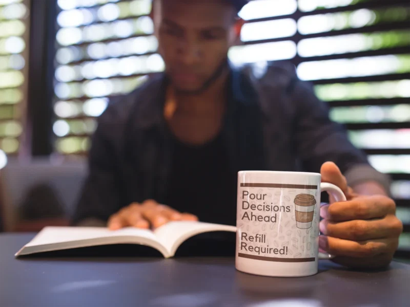 Man-reading-a-book-and-holding-a-coffee-cup-mockup.