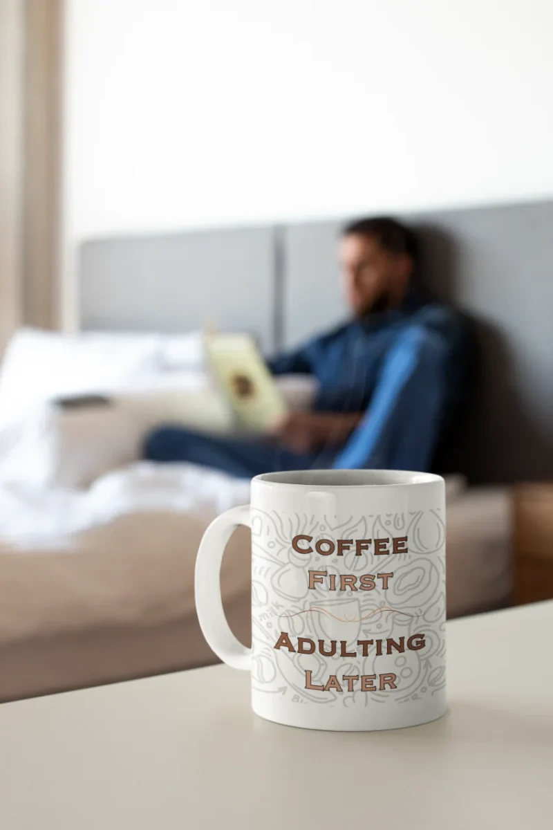 coffee-mug-mockup-with-a-man-reading-a-book-in-the-background.